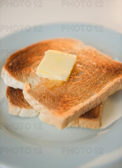 Close up of toasts with butter on plate. Photo : Jamie Grill Photography