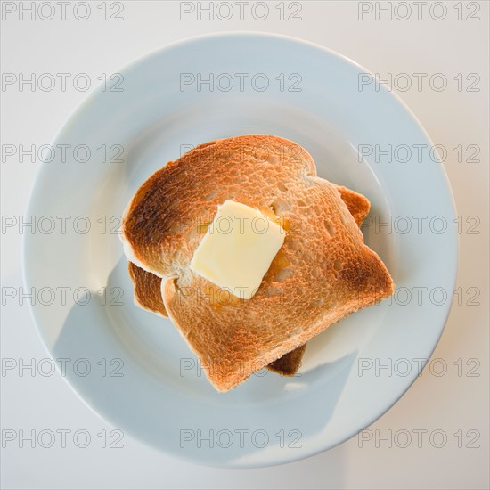 Close up of toasts with butter on plate. Photo : Jamie Grill Photography