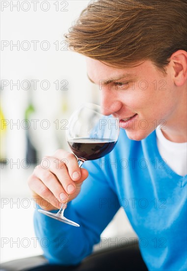 Young man tasting red wine. Photo : Daniel Grill