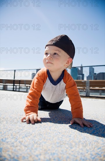 USA, New York City, Brooklyn, baby boy (0-1 years) crawling on sidewalk. Photo : Maisie Paterson