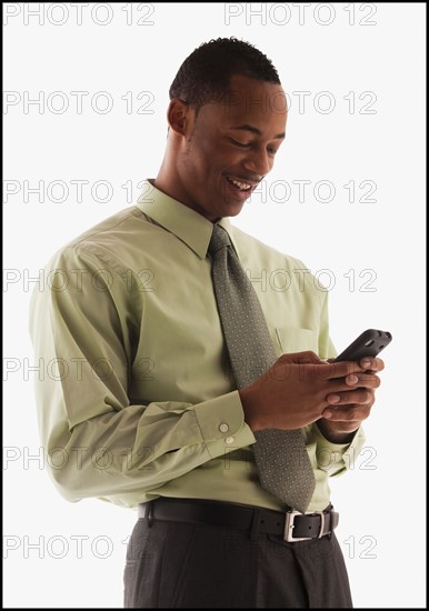 Young businessman using mobile phone . Photo : Mike Kemp