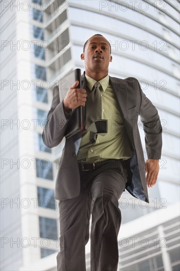 USA, Utah, Salt Lake City, Young businessman running in office building. Photo : Mike Kemp