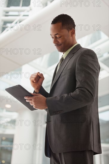 Content young businessman examining file. Photo : Mike Kemp