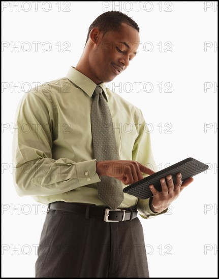 Content young businessman examining file. Photo : Mike Kemp