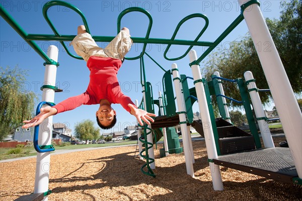 USA, California, Boy (12-13) climbing at playground. Photo : Noah Clayton