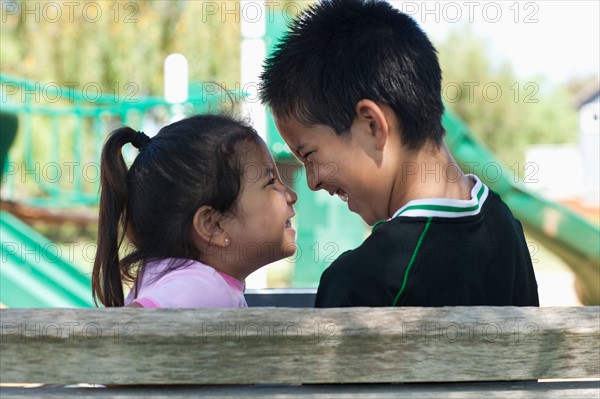 Brother and sister (4-13) face to face at playground. Photo : Noah Clayton