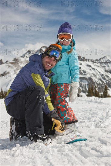 USA, Colorado, Telluride, Father and daughter (10-11) posing with snowboards in winter scenery. Photo : db2stock