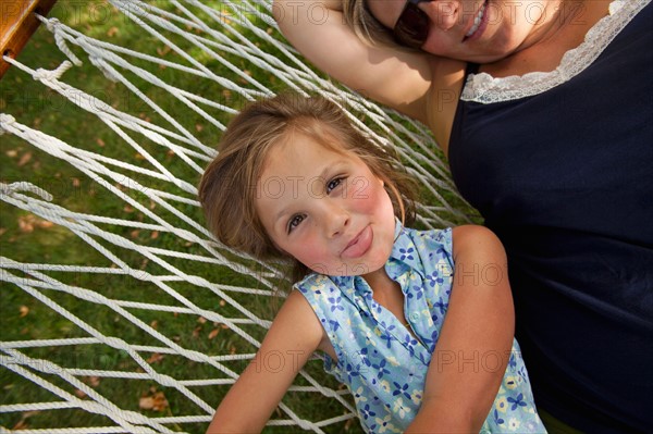 Portrait of girl (4-5) with mother in hammock. Photo : Noah Clayton