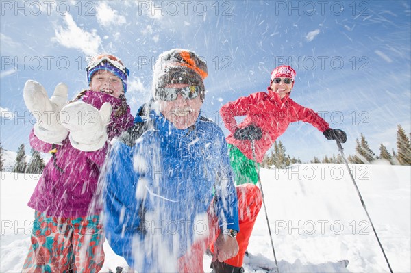 USA, Colorado, Telluride, Grandparents with girl (10-11) throwing snowballs at camera. Photo : db2stock