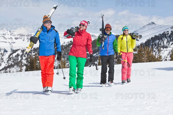 USA, Colorado, Telluride, Family with adult offspring walking in winter scenery carrying ski. Photo : db2stock