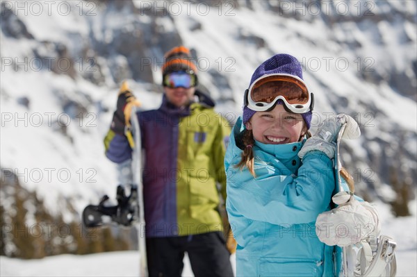 USA, Colorado, Telluride, Father and daughter (10-11) posing with snowboards in mountain scenery. Photo : db2stock