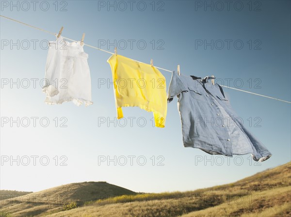 Laundry hanging on clothesline against blue sky.