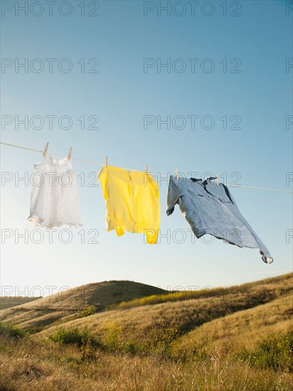 Laundry hanging on clothesline against blue sky.