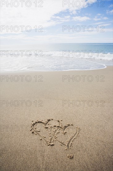 USA, Massachusetts, Hearts drawn on sandy beach. Photo : Chris Hackett