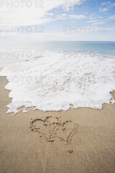 USA, Massachusetts, Hearts drawn on sandy beach. Photo : Chris Hackett