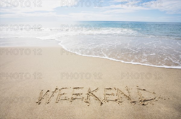 USA, Massachusetts, Word "weekend" drawn on sandy beach. Photo : Chris Hackett