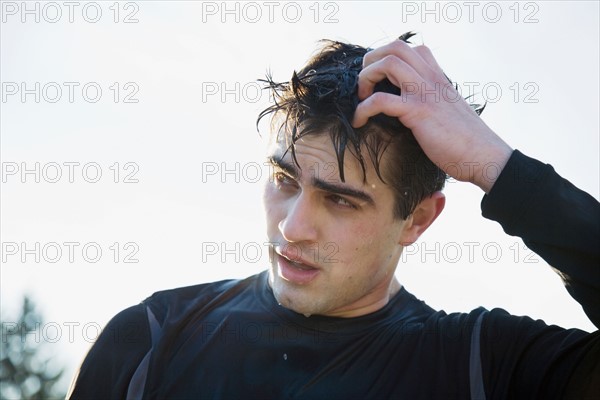 Portrait of man in sports clothing scratching head. Photo : Maisie Paterson