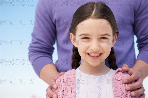 Portrait daughter (8-9) embraced by father.