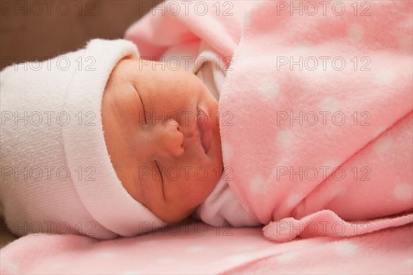 Baby girl (0-1 month) sleeping on sofa. Photo : Mike Kemp