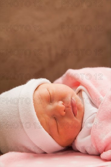 Baby girl (0-1 month) sleeping on sofa. Photo : Mike Kemp