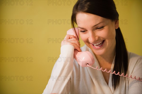 Smiling young woman talking on phone. Photo : Jamie Grill Photography