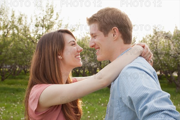 USA, Utah, Provo, Young couple embracing in orchard. Photo : Mike Kemp