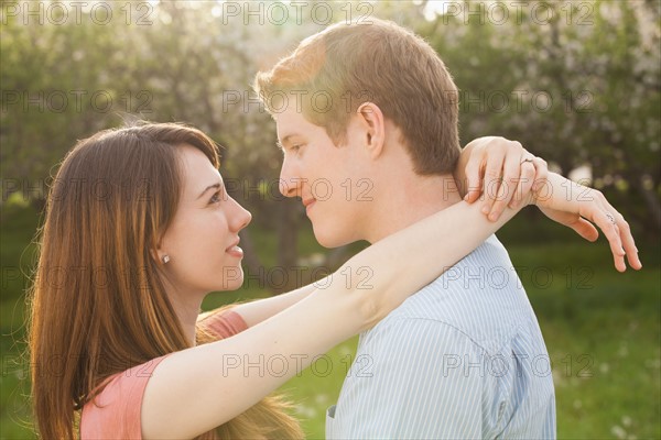 Young couple embracing in orchard. Photo : Mike Kemp