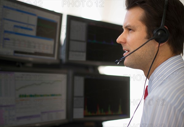 Financial worker analyzing data displayed on computer screen.