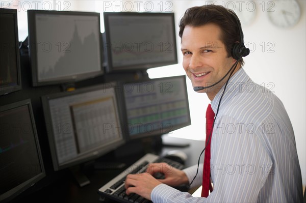 Portrait of financial worker analyzing data displayed on computer screen.