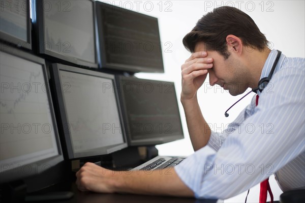 Upset financial worker analyzing data displayed on computer screen.