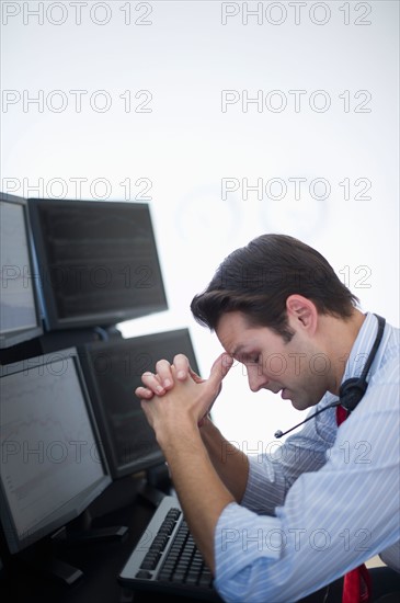 Upset financial worker analyzing data displayed on computer screen.