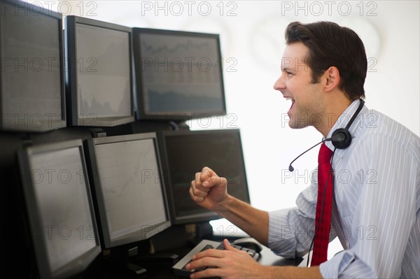 Financial worker analyzing data displayed on computer screen.