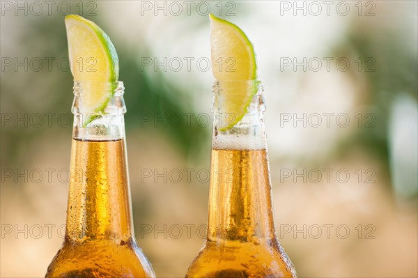 Two beer bottles with lime wedges.