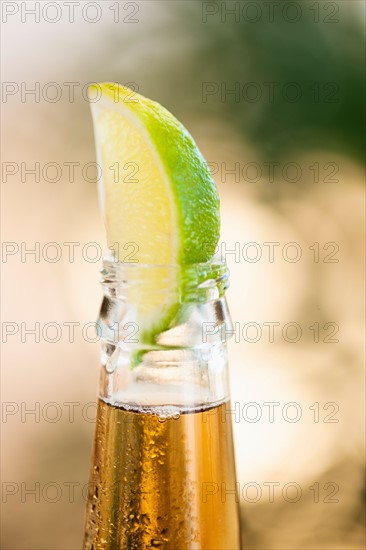 Beer bottle with lime wedge.