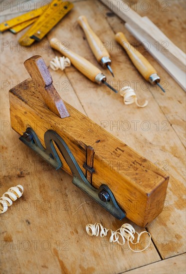 Close up of plane and chisels on wood.