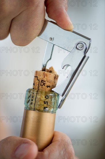 Man opening wine bottle.