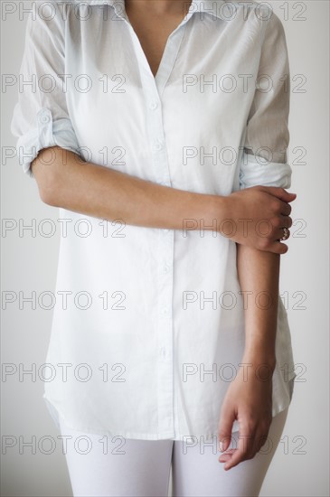 Mid section of woman dressed in white.