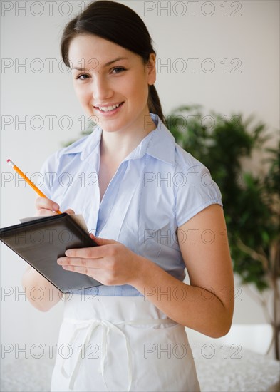 Portrait of smiling waitress taking order. Photo : Jamie Grill Photography
