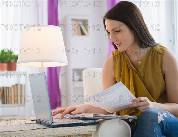 Young woman paying bills on line. Photo : Jamie Grill Photography