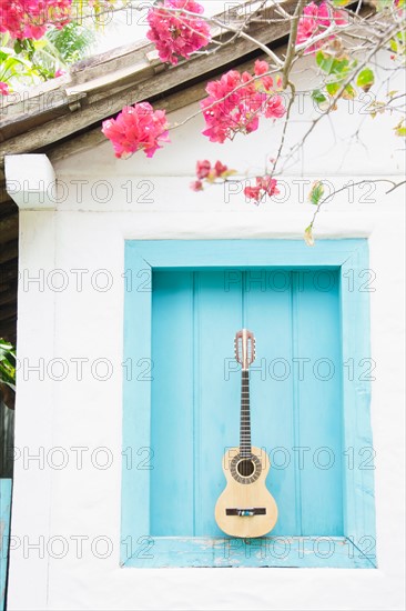 Brazil, Bahia, Trancoso, Guitar against building wall. Photo : Jamie Grill Photography