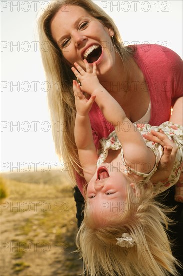 Mother playing with daughter (12-17 months) and laughing.