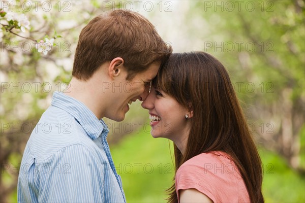 USA, Utah, Provo, Young couple face to face in orchard. Photo : Mike Kemp