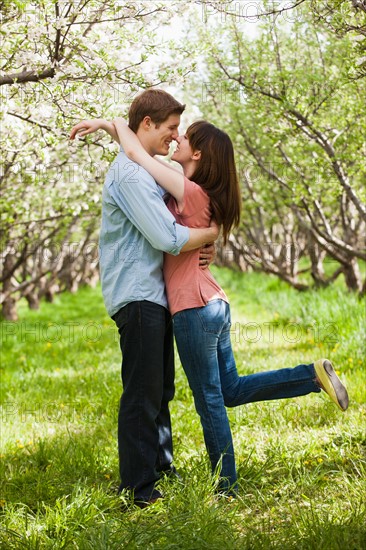 USA, Utah, Provo, Young couple embracing in orchard. Photo : Mike Kemp