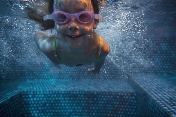 Portrait of girl (4-5) swimming underwater. Photo : King Lawrence