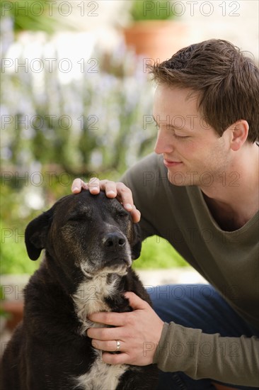 Man stroking dog. Photo : Rob Lewine