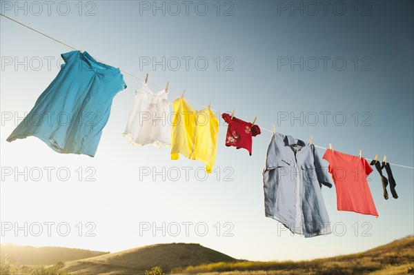 Laundry hanging on clothesline against blue sky.