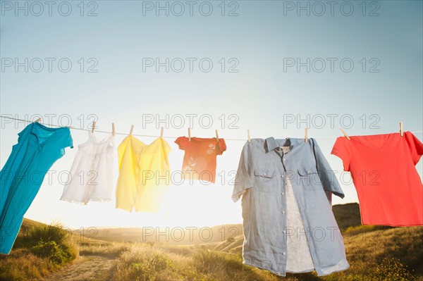 Laundry hanging on clothesline against blue sky.