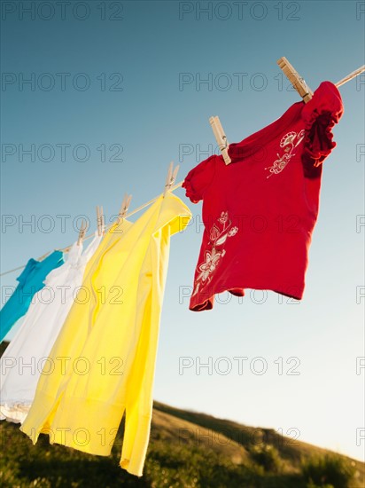 Laundry hanging on clothesline against blue sky.