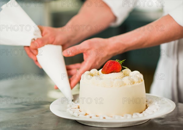 Pastry chef decorating cake.