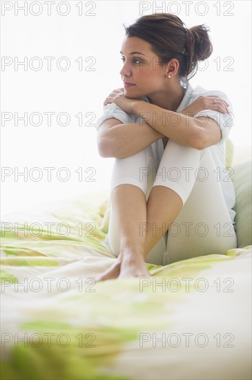 Portrait of cheerful young woman sitting with legs crossed.